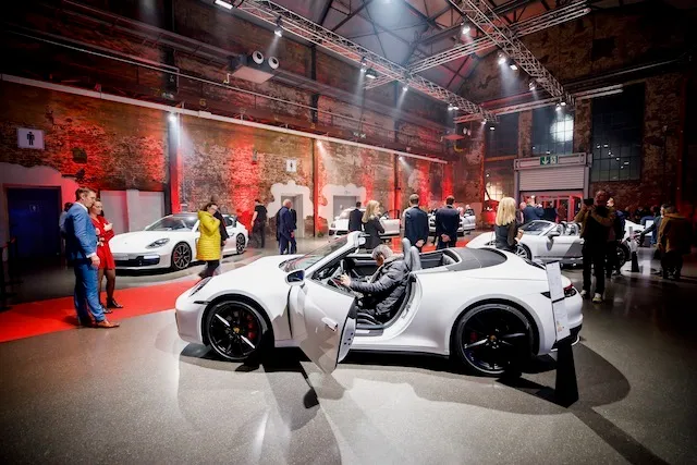 Showroom mit Fahrzeugen und Gästen